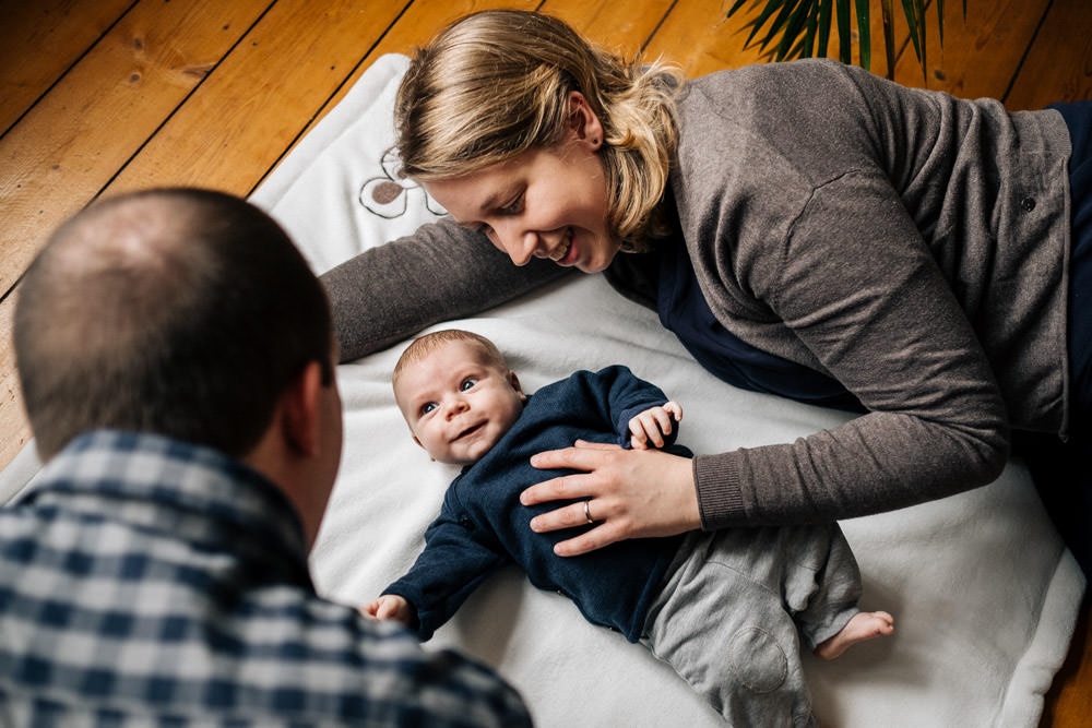 Baby und Eltern auf einer Decke