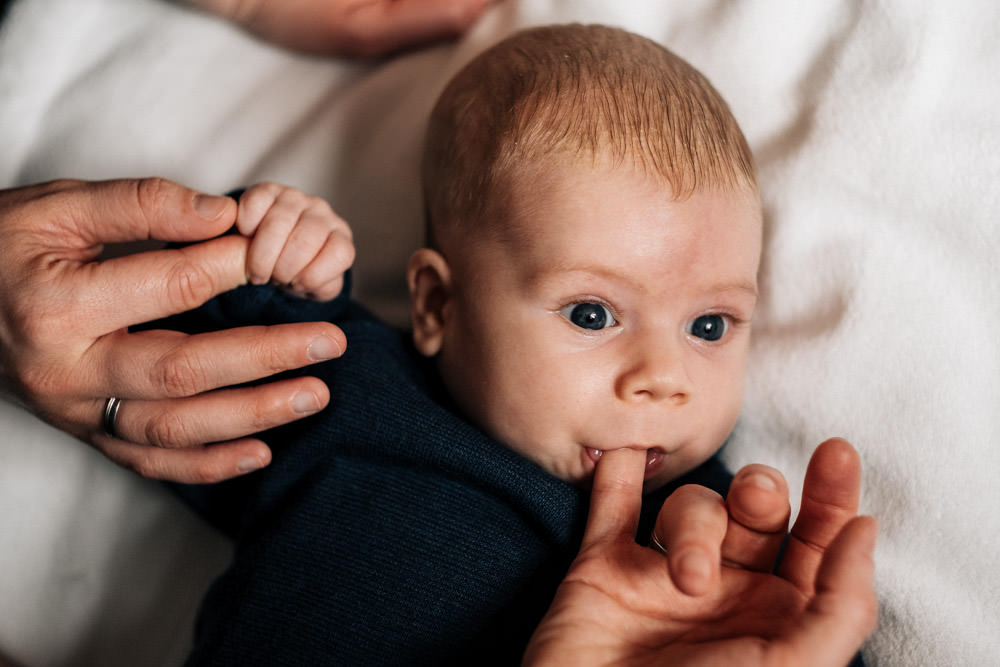 Baby nuckelt an Mamas Finger