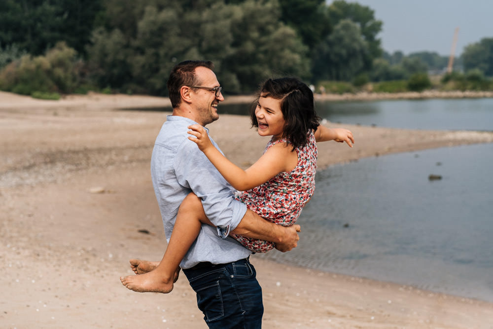 Tochter und Vater spielen am Strand