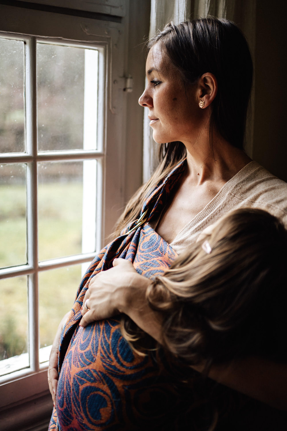 Mama hat Tochter im Tragetuch