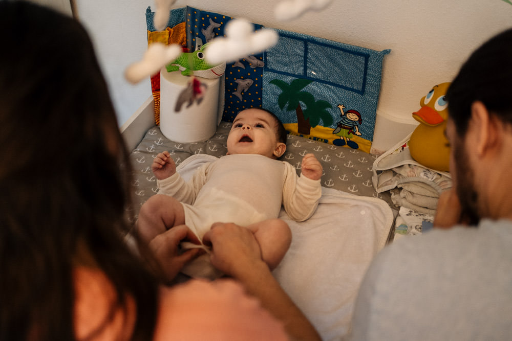 Baby mit Eltern am Wickeltisch - Babyfotografie, Familienfotografie