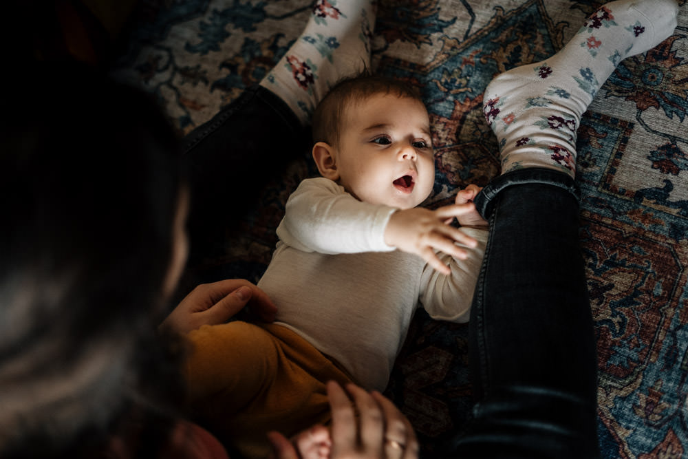 Baby spielt mit Mamas Hose - Babyfotografie, Familienfotografie