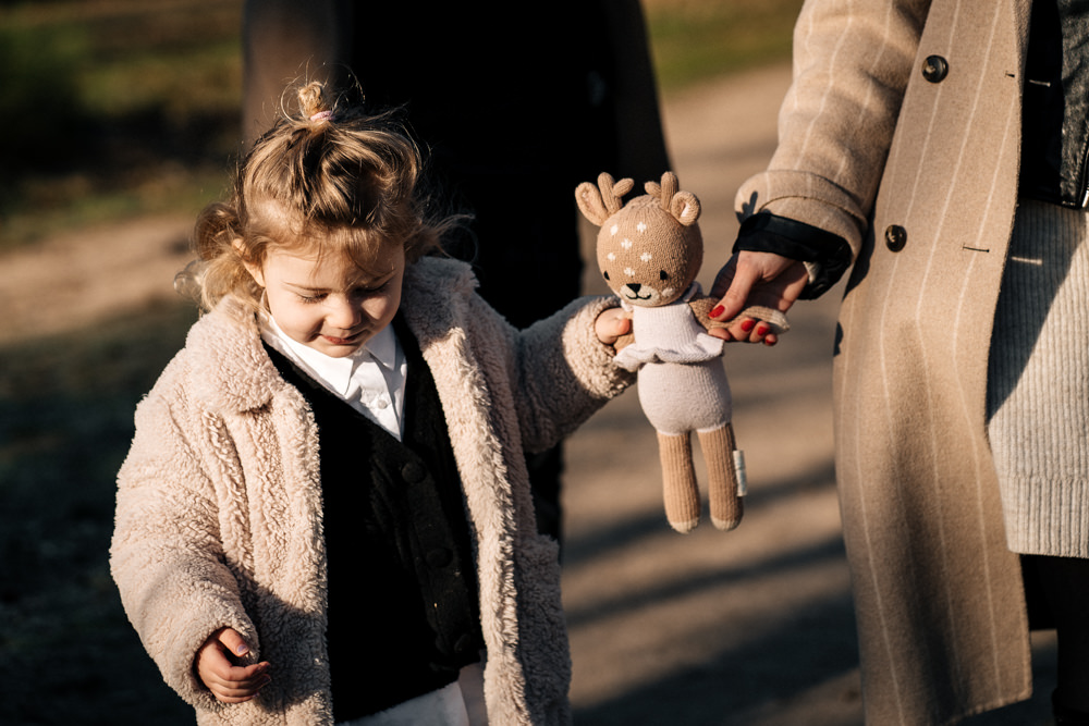 Tochter hält Händchen mit Kuscheltier und Mama Familienfotos