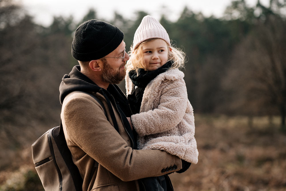 Blondes Mädchen bei Papa auf dem Arm familienreportage